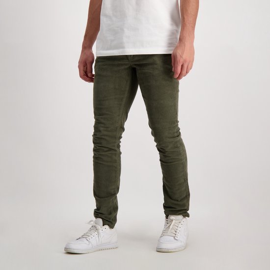 Heren broek van groen corduroy, slim fit, met witte sneakers.