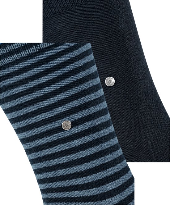 Detail van sokken: een paar gestreept blauw en grijs, één paar effen donkerblauw met zilveren knopje.