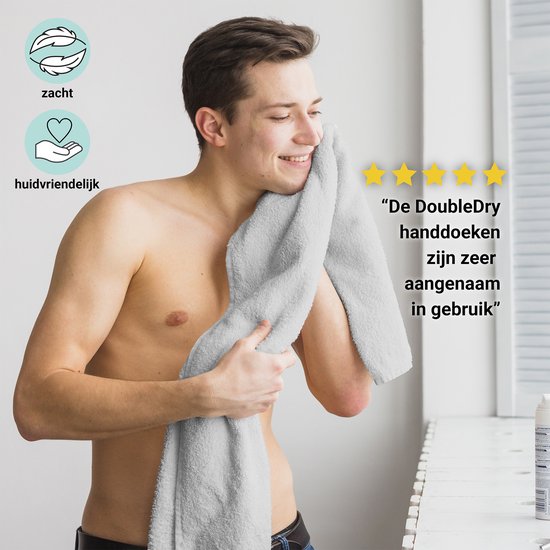 Man wrijft met een zachte, grijze handdoek over zijn gezicht. "De DoubleDry handdoeken zijn zeer aangenaam in gebruik."