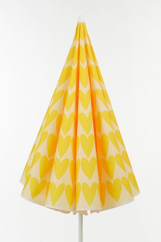 Een gesloten, gele parasol met een patroon van hartjes, staand op een witte achtergrond.