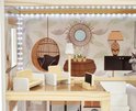 Poppenhuis woonkamer met rieten hangstoel, houten stoelen, vloerlamp en spiegel. Behang met bladeren.