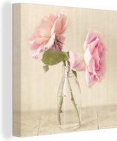 Canvas Schilderij Twee roze rozen als decoratie in een glazen flesje - 50x50 cm - Wanddecoratie