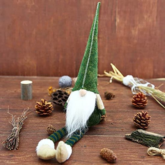 Un nain de Noël avec un bonnet pointu vert, une barbe blanche, des jambes rayées et des pieds beiges.