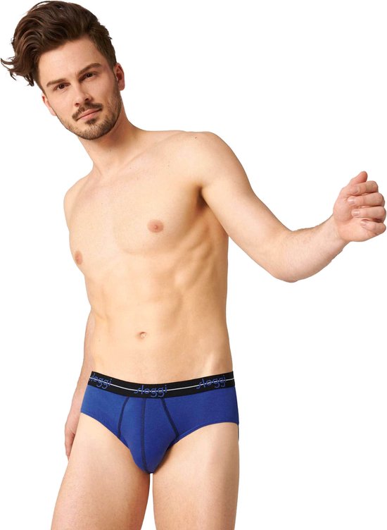 Man met getailleerde buik en baard, draagt een blauwe Sloggi slip met zwarte tailleband met logo.