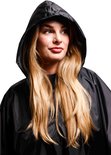 Model met blonde haren, met capuchon op en draagt een zwarte poncho.