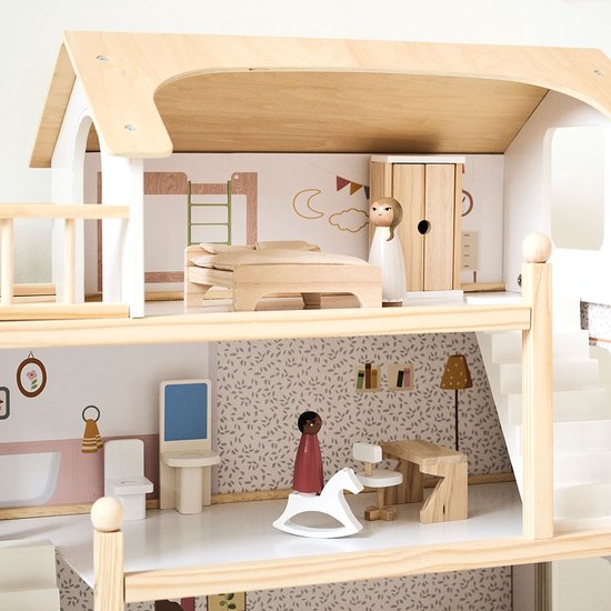 Detail van de bovenste verdieping van het houten poppenhuis: slaapkamer met bed, kast en balkon.