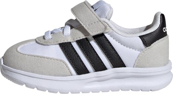 Zijaanzicht van een witte kindersneaker met grijze suède overlays, zwarte Adidas-strepen en klittenbandsluiting.