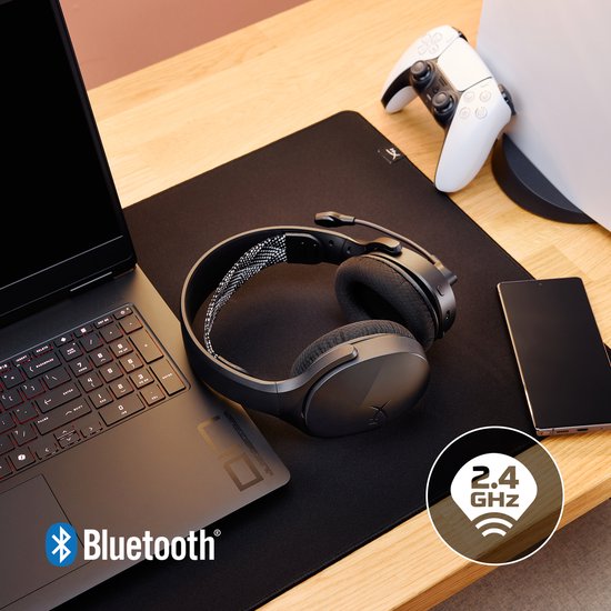 Zwarte draadloze headset met 2.4 GHz verbinding, naast een laptop, telefoon en gameconsole.