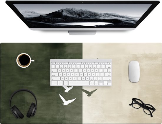Bureauonderlegger met groen en beige abstract patroon met vogels, koffie, toetsenbord, muis en bril.