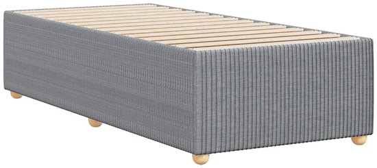 Cadre de lit gris clair en tissu avec sommier à lattes et pieds en bois, vu en angle.