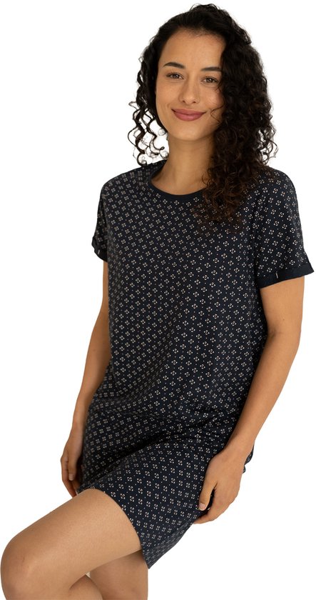 Model in een donkerblauw nachthemd met korte mouwen, met een repetitief patroon van kleine witte en roze bloemetjes.