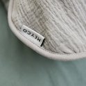 Label 'Meyco' op de lichtgrijze stof van een babyslaapzak.