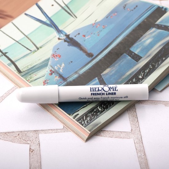 Witte Herome French Liner pen met blauwe tekst, liggend op een tijdschrift.