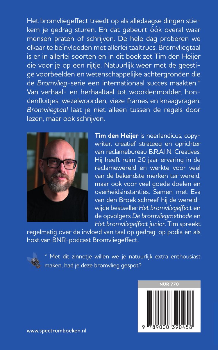 Man met bril, korte grijze haar, staand naast de tekst, kijkt naar de camera.