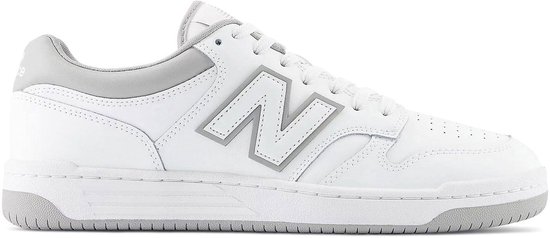 Witte lage sneaker van New Balance met grijze accenten en een groot grijs 'N' logo op de zijkant.