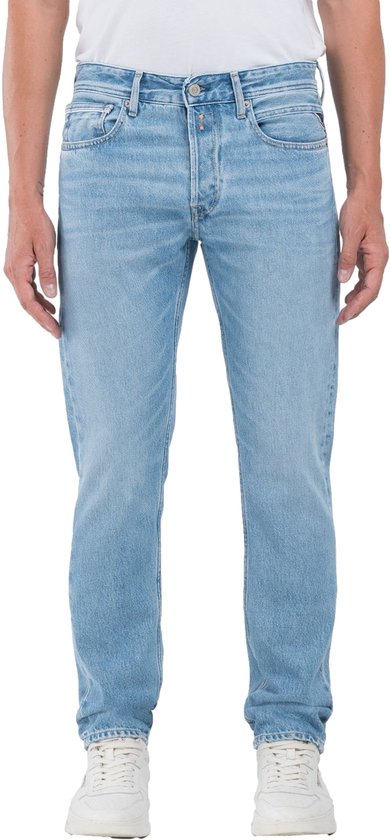 Homme portant un jean Replay bleu clair avec une fermeture boutonnée et cinq poches.