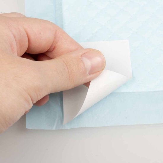 Een hand trekt een stukje wit papier van een blauw absorberend kussen.