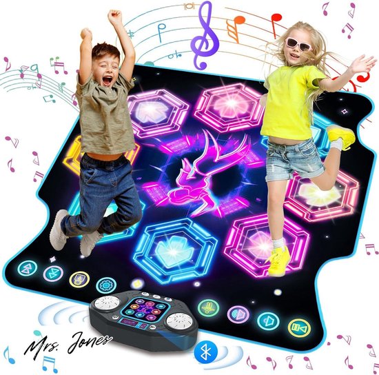 Twee kinderen springen enthousiast op een dansmat met oplichtende hexagonale knoppen in roze, blauw, cyaan en geel. Het bedieningspaneel staat voor de mat.