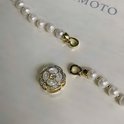 Gouden bloemvormige sluiting met zirkoon en parelmoer, met losse gouden karabijnhaken.