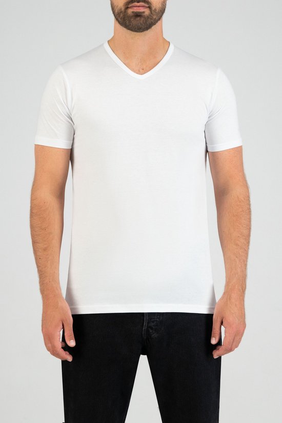 Man met baard draagt een wit V-hals T-shirt met korte mouwen en een spijkerbroek.