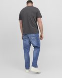 Man van achteren gezien, draagt een grijs t-shirt en blauwe jeans. Hij draagt witte sneakers.