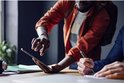 Twee mannen die samenwerken aan een tablet en notities maken met een pen.