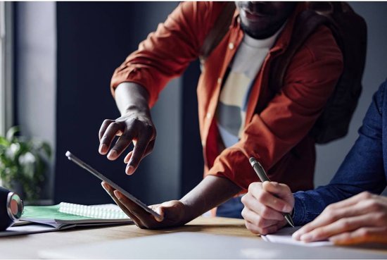 Twee mannen die samenwerken aan een tablet en notities maken met een pen.