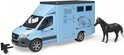 Lichtblauwe Bruder paardenwagen met een paard ernaast en een trekhaakje. Dewagen heeft een afbeelding van een springend paard.