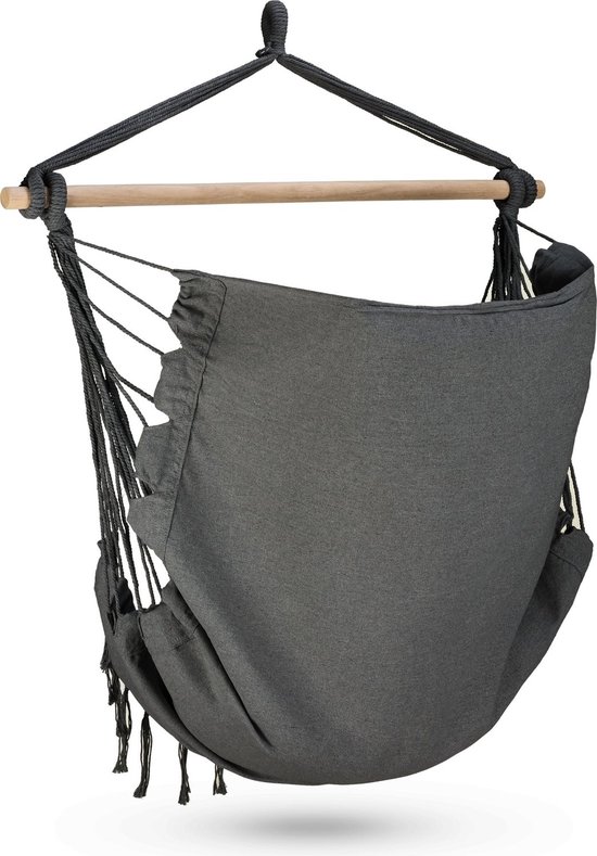 Donkergrijze hangstoel met houten spreidstok en franjes.