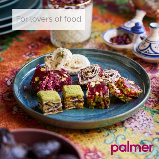 Een turkooizen aardewerken bord met een assortiment baklava en Turks fruit.