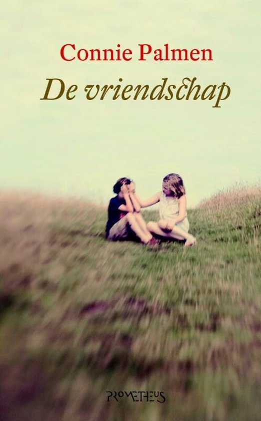 Boekcover 'De vriendschap' met twee meisjes op een heuvel. Titel en auteur in rode en zwarte letters.