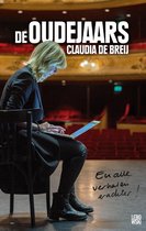 Claudia de Breij zit op een stoel met een laptop. Ze zit op een podium met rode stoelen op de achtergrond.
