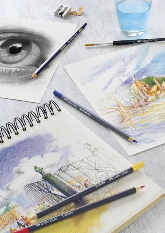 Een schets van een oog en een stad met potloden, puntenslijper, waterglas en verfkwast.