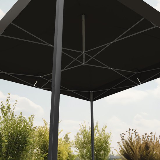 Onderkant van een zwarte partytent met het metalen frame zichtbaar. Achtergrond van groen gebladerte en blauwe lucht.