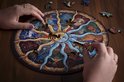 Twee handen leggen houten dierenpuzzelstukjes op de dierenriempuzzel. Houten tafel als achtergrond.