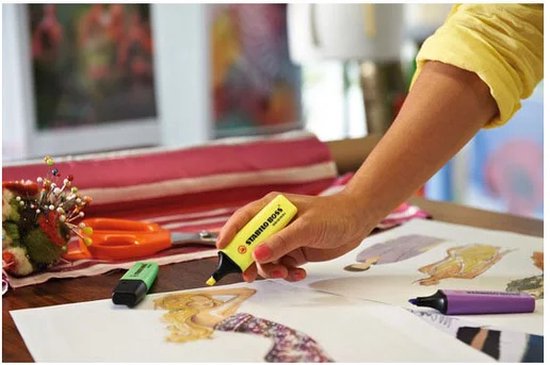 Hand met gele STABILO BOSS ORIGINAL markeerstift, tekent op schets.