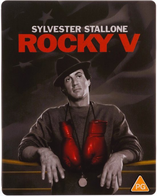 Sylvester Stallone als Rocky in "Rocky V", met rode bokshandschoenen om zijn nek en een hoed.