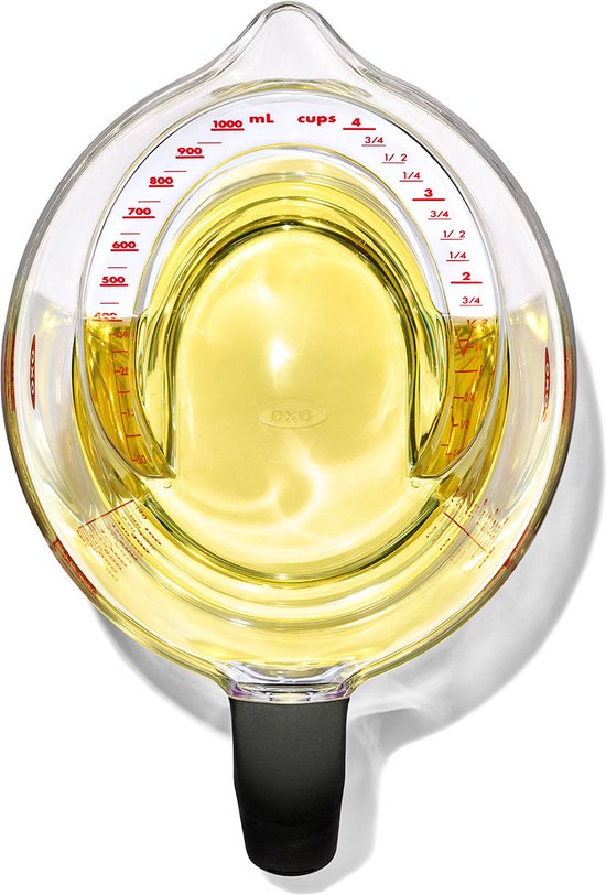 Pichet mesureur transparent de 1 litre avec un liquide jaune, une échelle inclinée et une poignée noire.