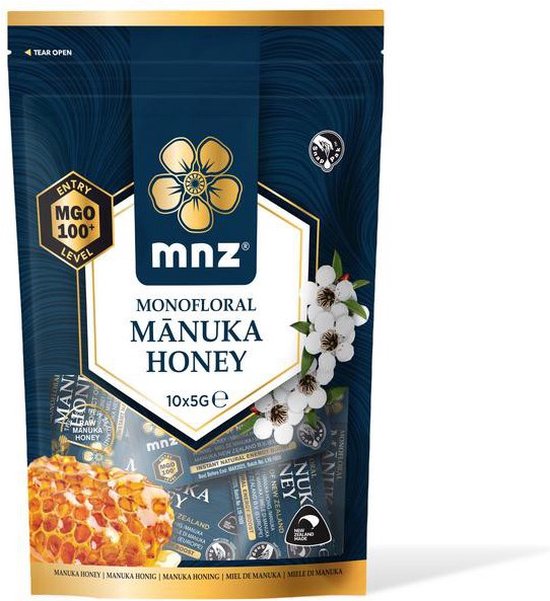 Manuka New Zealand monofluoraal manuka honing, 10x5g, MGO 100+ level, met takjes bloesems en honingraat.