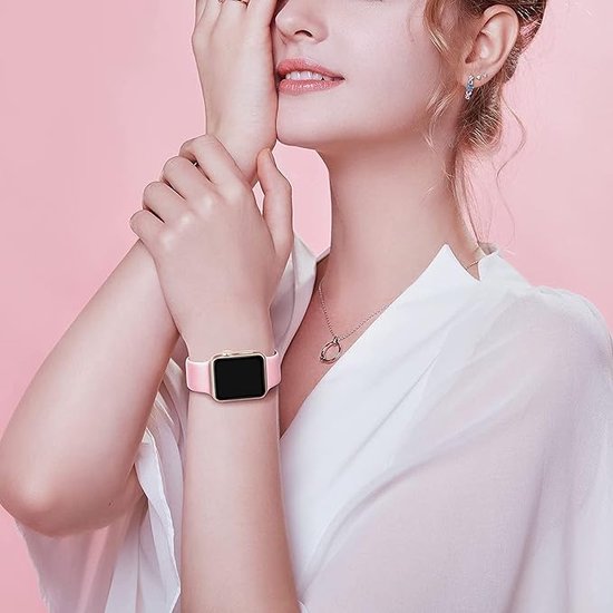 Model met pols met lichtroze Apple Watch bandje en gouden kast.