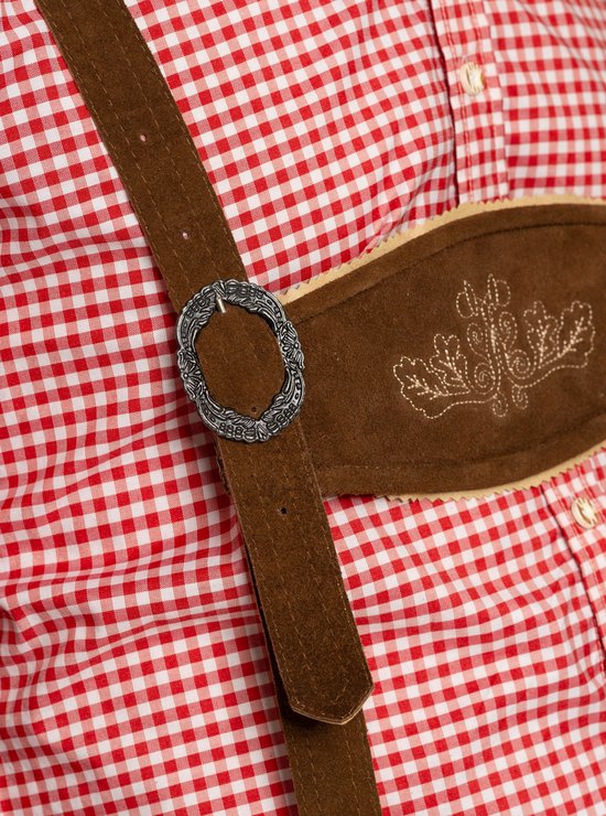 Gros plan de la culotte de leder brune avec motifs floraux brodés sur le devant et la boucle métallique de la bretelle.