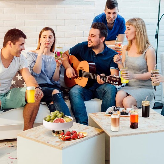 Groep vrienden op een feestje, zittend op een bank en aan tafel, drinkend uit Sipy glazen.