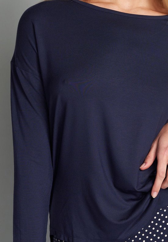 Donkerblauwe longsleeve met boothals, gedragen op een witte polkadot broek.