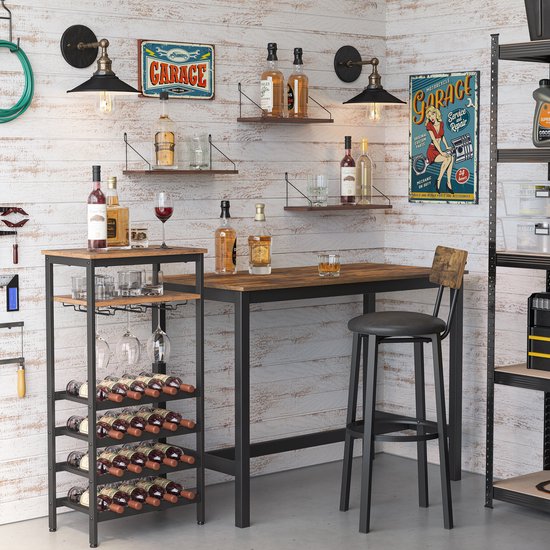 Een stijlvolle baropstelling in een garage-achtige ruimte, met een metalen en houten bartafel, een kruk en een wijnrek met glazen en flessen.
