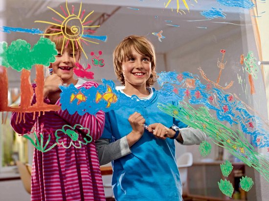 Twee kinderen, een meisje in roze gestreepte jurk en een jongen in blauw shirt, tekenen op een raam.