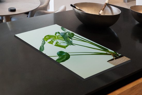 KitchenYeah® Inductie beschermer 30x52 cm - Monstera in een pot met een lichte achtergrond - Kookplaataccessoires - Afdekplaat voor kookplaat - Inductiebeschermer - Inductiemat - Inductieplaat mat