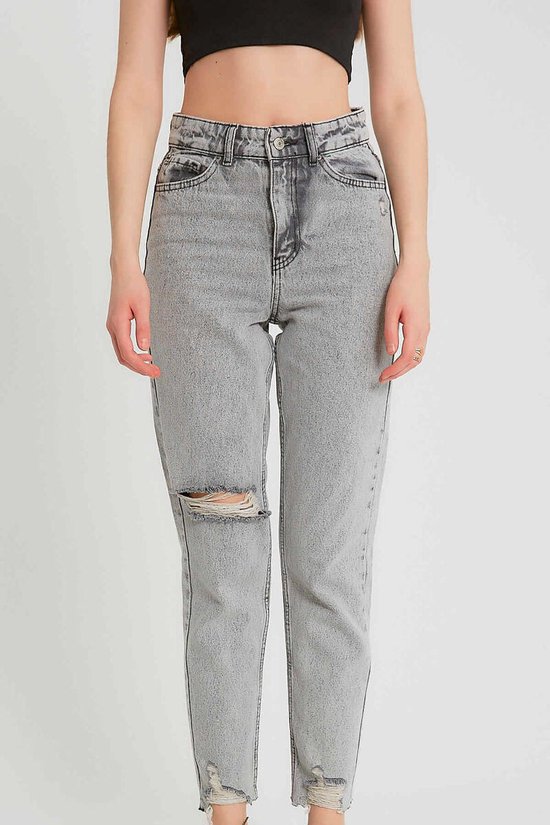 Model van voren gezien met grijze, gescheurde high-waist spijkerbroek met rafelige zoom.