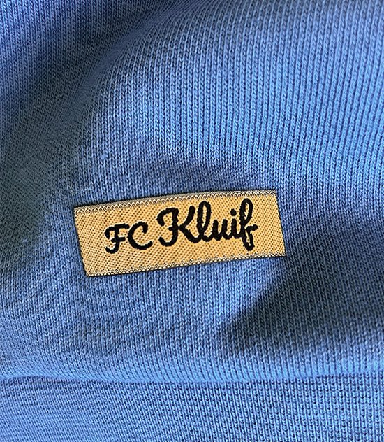 Label met 'FC Kluif' op een blauwe sweater.