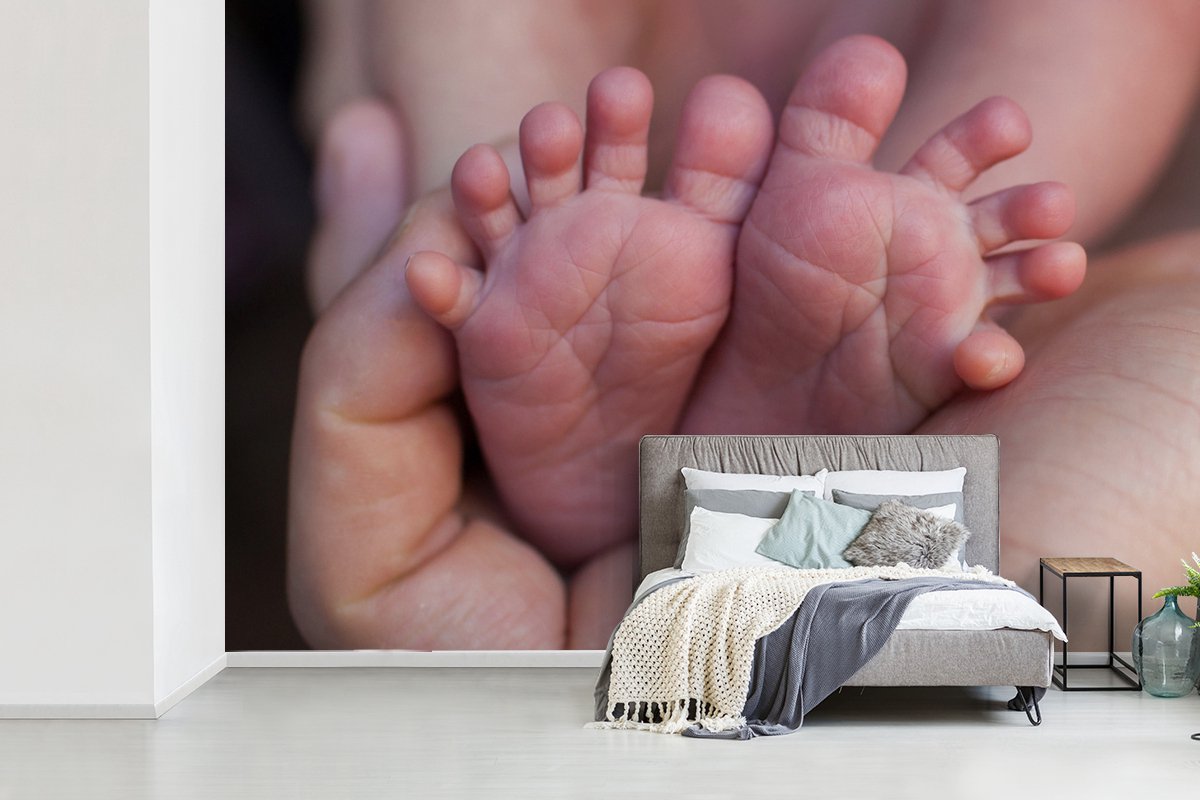Behang - Fotobehang Close-up van de voeten van een pasgeboren baby - Breedte 450 cm x hoogte 300 cm