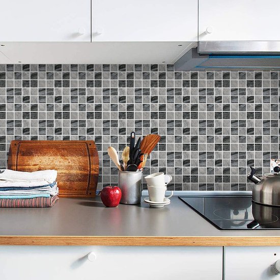 Dosseret de cuisine avec carreaux de mosaïque en marbre gris, avec des ustensiles de cuisine.